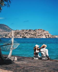 two people sitting on a dock looking at the water at Terre Cretoise in Fourní