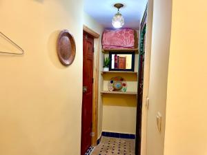 a hallway with a door and a shelf with books at Riad Noor Medina in Fez