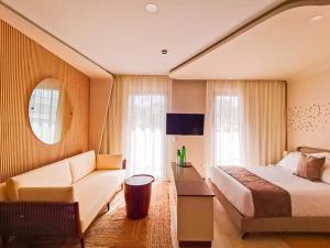 a hotel room with a bed and a couch at Alizee Tower in Playa del Carmen