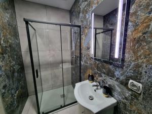 a bathroom with a glass shower and a sink at Villa Międzyzdroje in Międzyzdroje
