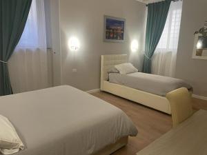 um quarto com 2 camas, um sofá e uma janela em Holiday House Roma Vaticano em Roma