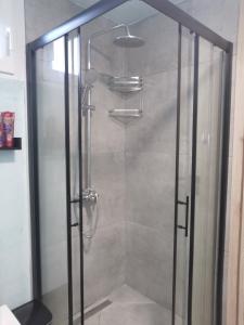 um chuveiro com uma porta de vidro na casa de banho em Boho Sisi Resort em Sissi