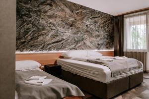 um quarto de hotel com duas camas com toalhas em Park Hotel Sóstó em Nyíregyháza