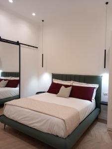 1 dormitorio con 1 cama grande con almohadas rojas y blancas en Porto 55 en Nápoles