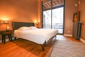 1 dormitorio con cama y ventana grande en REIMS-ESCAPADE terrasses, en Reims