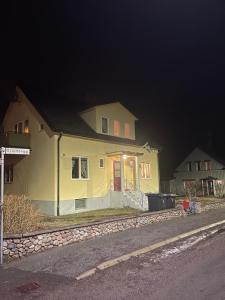 ein gelbes Haus am Straßenrand nachts in der Unterkunft Bootsmanns Hütte 7 Personen in Virserum