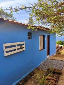 uma casa azul com uma janela e uma cerca em Casa Beco do Céu em Fernando de Noronha