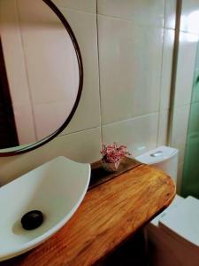 een badkamer met een wastafel, een spiegel en een toilet bij Casa Beco do Céu in Fernando de Noronha