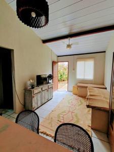 um quarto com uma mesa e duas cadeiras e uma televisão em Casa Beco do Céu em Fernando de Noronha