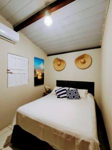 a bedroom with a bed and two hats on the wall at Casa Beco do Céu in Fernando de Noronha +24 photos