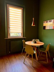 ein Esszimmer mit einem Tisch, Stühlen und einem Fenster in der Unterkunft La Casetta di Elena in Pesaro