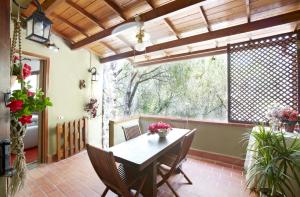 a dining room with a table and chairs and a large window at Pinus Village Appartamento in Santa Margherita di Pula