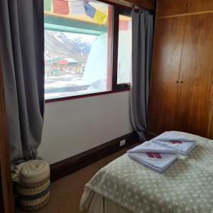 a room with a bed and a window with towels at Departamento en Lomas Blancas, Penitentes in Los Penitentes