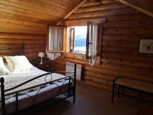 a bedroom with a bed and a window in a log cabin at Chalet con vistas al lago Matemale en Les Angles in Les Angles