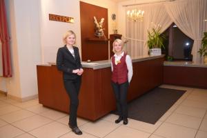 dos mujeres están de pie junto a un mostrador en Hotel Pod Dębami en Terespol