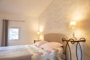 a bedroom with a bed with two pillows and a lamp at Appartement spacieux Rochereau in L'Isle-sur-la-Sorgue