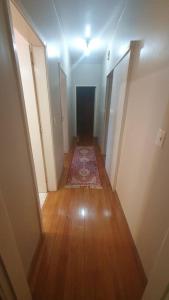 un pasillo vacío con una alfombra en el suelo de madera en Casa aconchegante e tranquila, em Veranópolis/RS., en Veranópolis