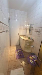Baño pequeño con lavabo y espejo en Casa aconchegante e tranquila, em Veranópolis/RS., en Veranópolis
