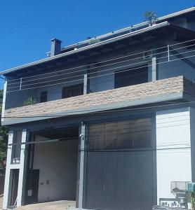 una casa con dos puertas de garaje y un techo en Casa aconchegante e tranquila, em Veranópolis/RS., en Veranópolis