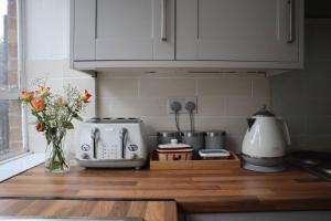a kitchen counter with a vase of flowers on it at Charming 3Bed Home in High Barnet in Barnet