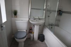 y baño con aseo, lavabo y ducha. en Charming 3Bed Home in High Barnet, en Barnet