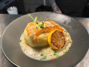 a plate of food with a piece of fish and a lemon at Kings Arms Hotel in Sandwich +14 photos