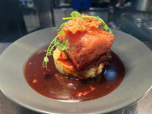a plate of food with a piece of meat with sauce at Kings Arms Hotel in Sandwich