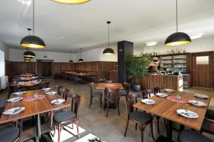 a restaurant with wooden tables and chairs and a bar at Hospoda U Máně in Řepiště