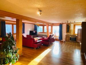 a living room with red furniture and windows at Ferienhaus Schweissing in Fröhnd