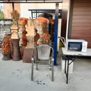 a chair sitting next to a desk with a laptop at PA House Apartment in Bangkok