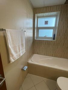 uma casa de banho com uma banheira e uma janela em Holiday Home Master bed room in Ajman city UAE em Ajman