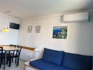 ein Wohnzimmer mit einem blauen Sofa und einem Tisch in der Unterkunft Cannes apartment with sea view and aircondition in Cannes
