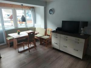 uma sala de estar com uma mesa e uma televisão e uma sala de jantar em Haus Holzer em Dorfgastein