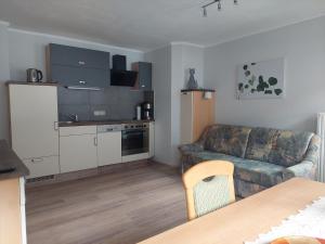 uma sala de estar com um sofá e uma cozinha em Haus Holzer em Dorfgastein