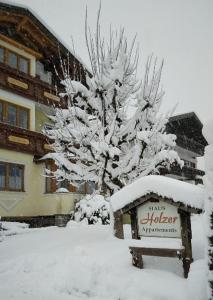 um sinal na neve em frente a uma casa em Haus Holzer em Dorfgastein