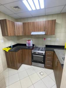 uma cozinha com armários de madeira e um fogão em Holiday Home Master bed room in Ajman city UAE em Ajman