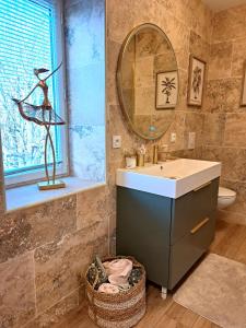 La salle de bains est pourvue d'un lavabo et d'un miroir. dans l'établissement gite Chezelle, à Saint-Georges-sur-Cher