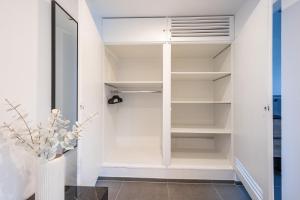 a white walk in closet with white shelves at Studio U1 in bester Lage in Radolfzell am Bodensee
