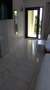 uma sala de estar com um grande piso de azulejo branco em MisBHaven Resort and Spa em Port Antonio