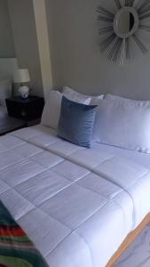 1 cama blanca grande en una habitación con espejo en MisBHaven Resort and Spa, en Port Antonio