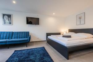 een slaapkamer met een bed en een blauwe bank bij Studio U1 in bester Lage in Radolfzell am Bodensee