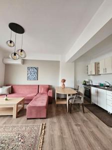 - un salon avec un canapé rose et une table dans l'établissement Cozy & Minimal Apartment Near Airport Peania, à Paianía