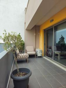 a plant in a pot sitting on a balcony at Cozy & Minimal Apartment Near Airport Peania in Paianía