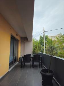 a balcony with a table and chairs and a potted plant at Cozy & Minimal Apartment Near Airport Peania in Paianía