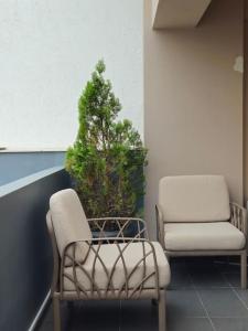 a room with two chairs and a christmas tree at Cozy & Minimal Apartment Near Airport Peania in Paianía