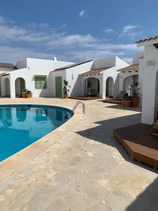 une villa avec une piscine en face d'une maison dans l'établissement apartamento nº 7 cala pregonda, à Cala Blanca