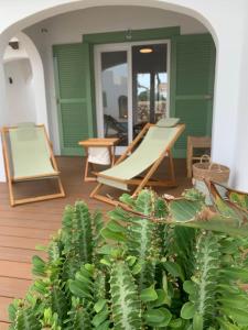 eine Veranda mit einer Hängematte, einem Stuhl und Pflanzen in der Unterkunft apartamento nº 7 cala pregonda in Cala Blanca