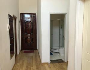 ein Badezimmer mit einem WC und einer Holztür in der Unterkunft cozy apartament with sea view in Tbilisi City