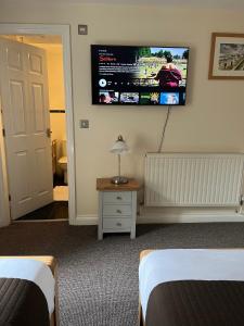 a hotel room with two beds and a flat screen tv at Roker Seafront Apartments in Sunderland