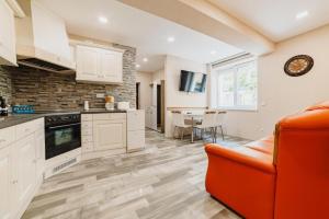 a kitchen with an orange couch and a table at Luxury Apartment Oasis in Timisul de Jos